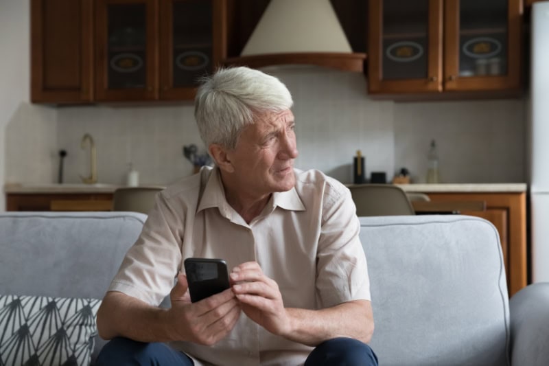 What’s That Smell Coming From My Furnace? Photo of a man looking concerned on his phone.